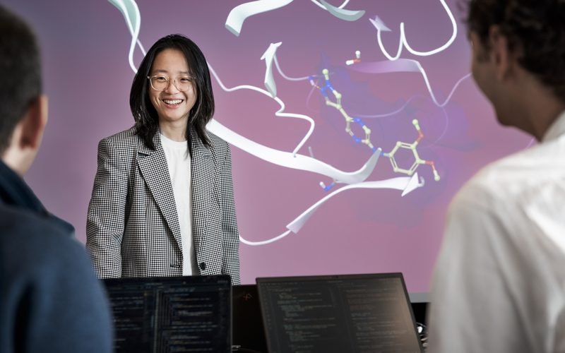 Colleague presenting to teammates in front of a large screen